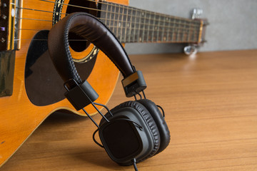 headphone and guitar on wood