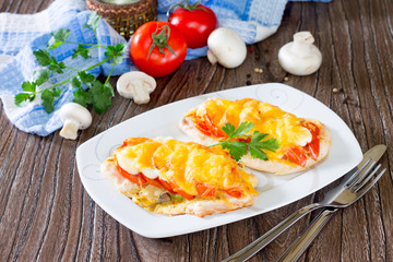 Chicken chops, fillets baked with mushrooms and cheese on a wood