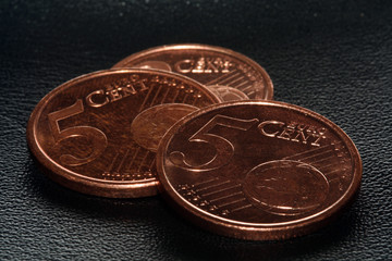 5 Cent Euro Coins on a black leather surface