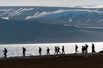 Silhouetted group of hikers in Barentsoya, Svalbard, Norway.