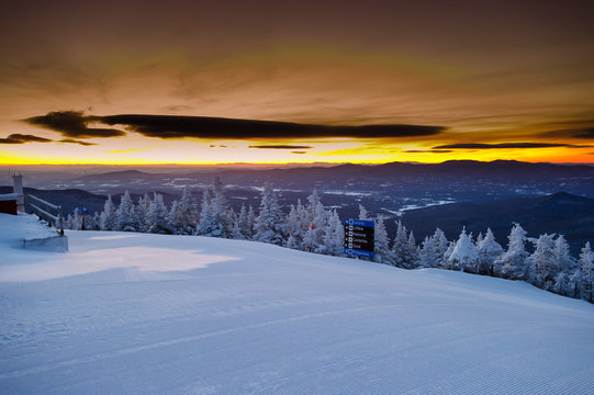Early morning golden sunrise over groomed ski trails in Vermont,