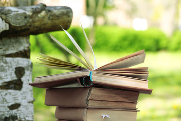 Stack of books on bench, outdoors