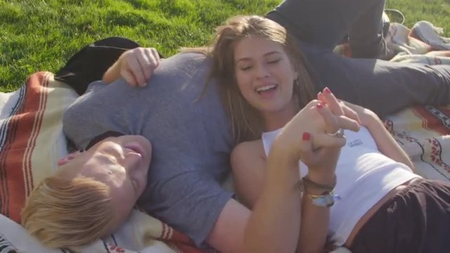 Attractive teen girl rests her head on her boyfriend 