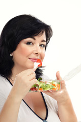 Black haired woman eating vegetable salad