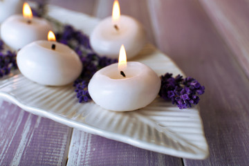 Obraz na płótnie Canvas Candles with lavender flowers on table close up