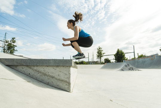 Sportive young woman training in a skate park