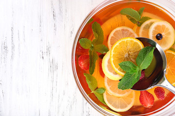 Fruity punch in glass bowl on wooden table, top view