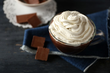 Cup of coffee with cream on color wooden background