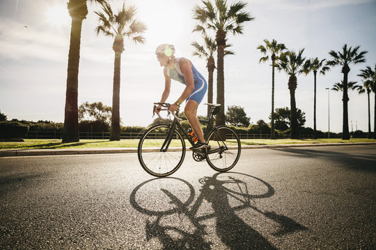 Spain, Mallorca, Sa Coma, triathlete training on bicycle