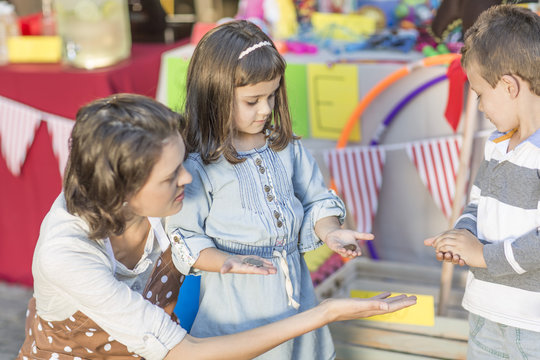 Kids having a garage sale counting money with mother