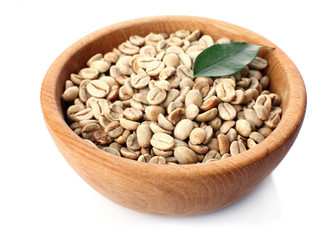 Green coffee beans with leaf in bowl isolated on white