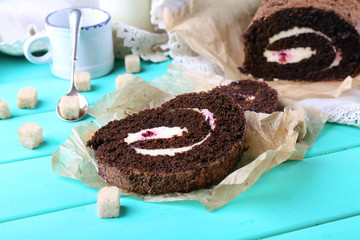 Delicious chocolate roll on wooden table, closeup