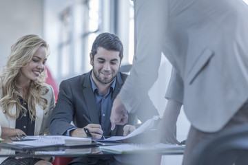 Smiling young man signing a contract