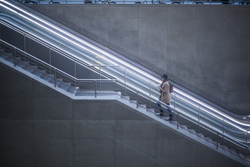 Young woman with coffee to go walking upstairs