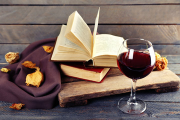 Beautiful composition with glass of wine with old books on table close up