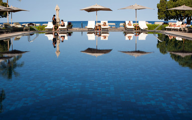 Pool at a luxury hotel in Kona Hawaii, in the distance people take a sun bath