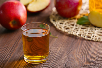 Glass of apple juice and fruits on table close up