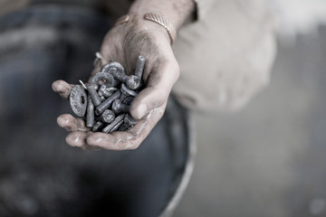 Hand holding bolts and screws