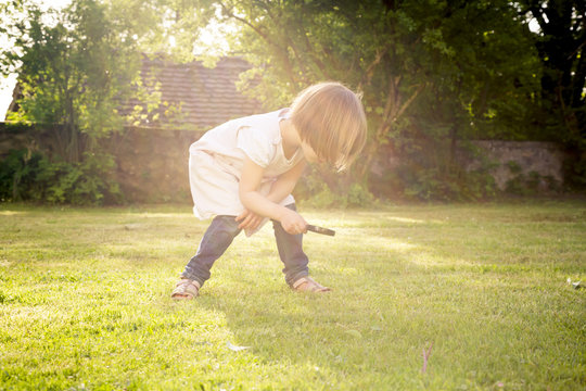Little girl on a meadow using magnifying glass