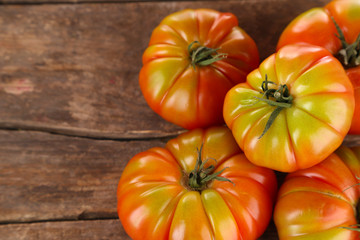 Green tomatoes on wooden table close up