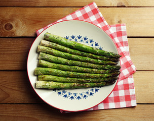 Roasted asparagus on plate on table background