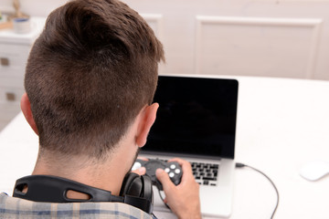 Young man playing computer games at home