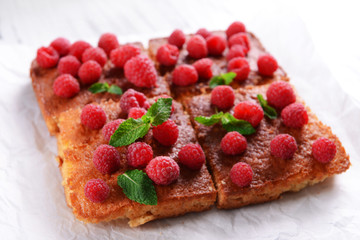 Fresh pie with raspberry on parchment on wooden table, closeup