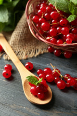 Ripe red currant in wicker basket on wooden background