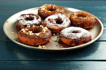 Delicious doughnuts with chocolate icing on table close up