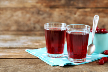 Two glasses with cherry juice on table, on light background