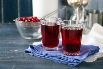 Sweet homemade cherry juice on table, on color background