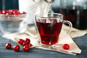 Sweet homemade cherry juice on table, on light background