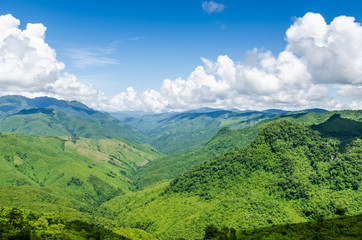 Fototapeta premium green mountains and blue sky with clouds