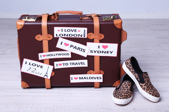 Suitcase with stickers on floor in room