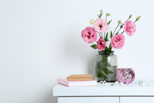 Beautiful flowers with books on wall background