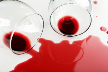 Spilled wine from glasses on white background