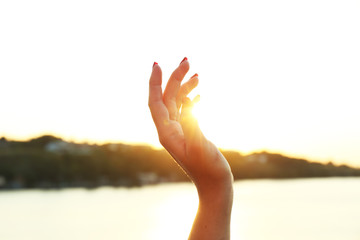 Female hand on sunny sky background