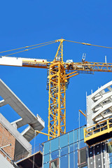 Crane and building construction site against blue sky