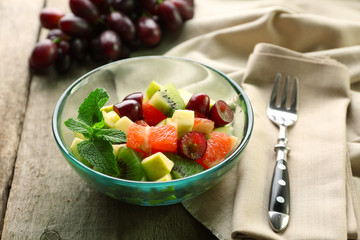 Fruit salad in glass bowl, on  wooden background