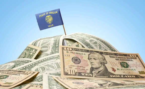 Flag of Oregon sticking in a pile of american dollars.(series)