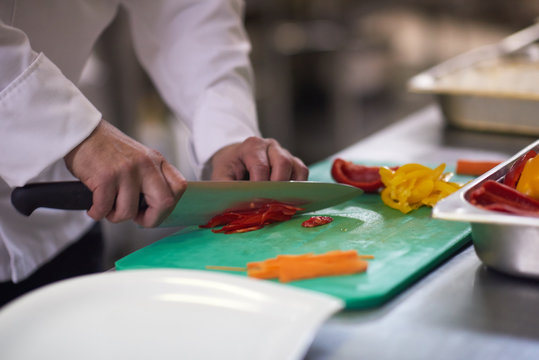 Chef In Hotel Kitchen  Slice  Vegetables With Knife