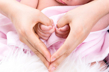 Baby  holding mother making hearth symbol hands