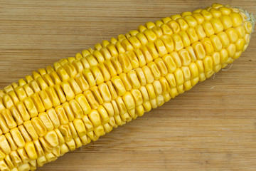 Grains of ripe corn on wooden background