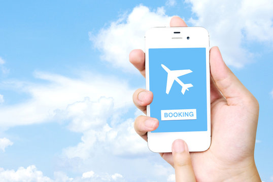 Hand holding mobile phone with airline tickets online booking on