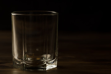 glass of whiskey with ice on a wooden table. Cognac, brandy.