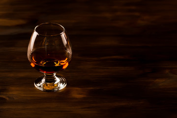 glass of whiskey with ice on a wooden table. Cognac, brandy.