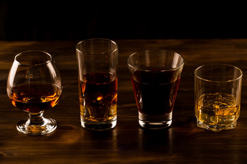 glass of whiskey with ice on a wooden table. Cognac, brandy.