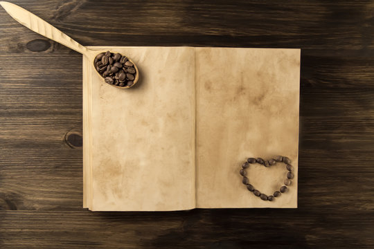 roasted coffee beans on old vintage open book. Menu, recipe, mock up. Wooden background.