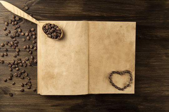 roasted coffee beans on old vintage open book. Menu, recipe, mock up. Wooden background.