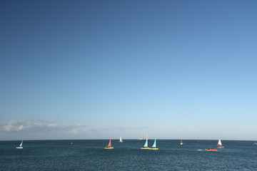 Obraz premium Yachts at sea off Swanage beach in Dorset